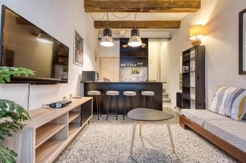 a living room with a couch and a bar with stools at Archbishop Street Valletta Apartment in Valletta