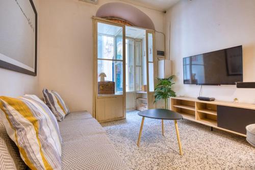 a living room with a couch and a flat screen tv at Archbishop Street Valletta Apartment in Valletta