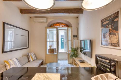 a living room with a couch and a tv at Archbishop Street Valletta Apartment in Valletta