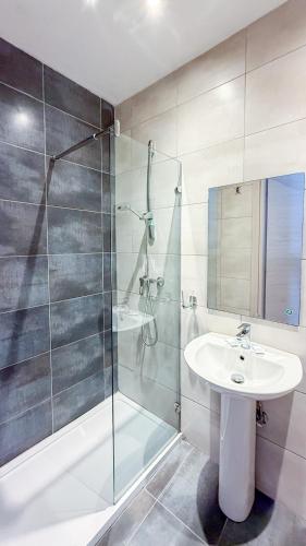 a bathroom with a sink and a glass shower at Island Guesthouse in Il-Gżira