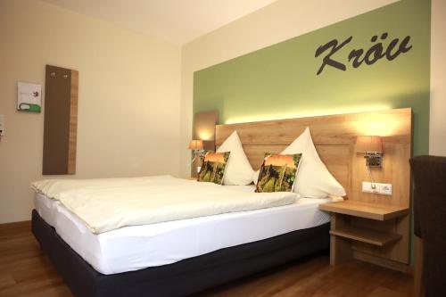 a bedroom with a king sized bed with a wooden headboard at Weinhaus Gräfen in Cochem