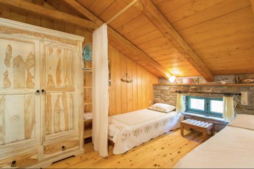 a bedroom in a log cabin with a bed and a window at villapetramarina in Tsakaíoi