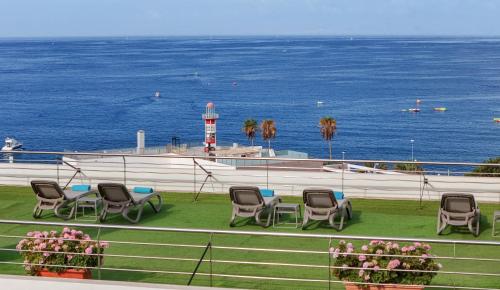 a group of chairs and a lighthouse in the ocean at AluaSoul Costa Adeje - Adults Only in Adeje