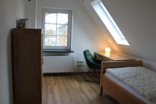 a bedroom with a bed and a desk and a window at Ferienhaus Schünhoff in Schneverdingen