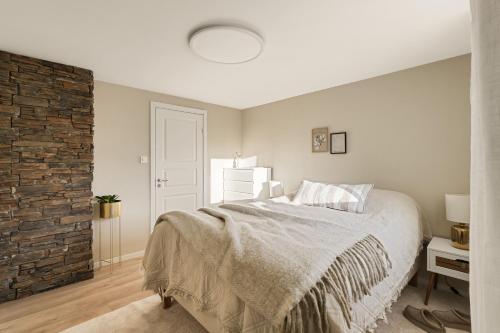 a bedroom with a bed and a brick wall at Aurora Bliss - Waterfront Jacuzzi & Sauna near Bergen in Askøy