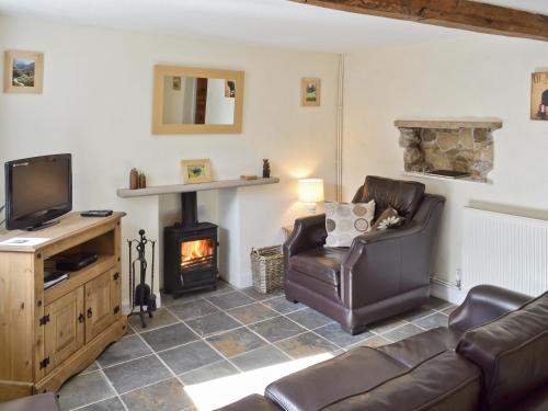 a living room with a couch and a fireplace at Jeremiah Cottage in Bradwell