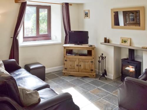 a living room with a couch and a tv at Jeremiah Cottage in Bradwell