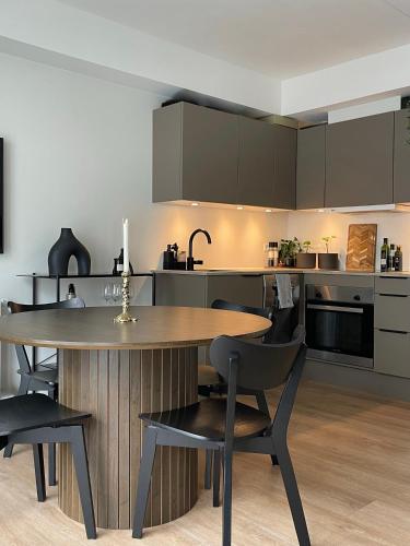 a kitchen with a wooden table and chairs at Central nyrenoveret lejlighed i Aalborg in Aalborg
