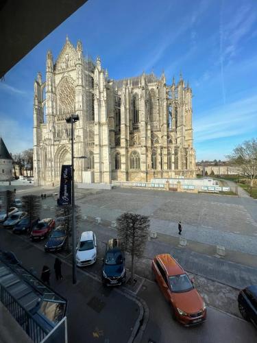a large church with cars parked in front of it at Le Sweet Escape - Vue Sur La Cathédrale in Beauvais