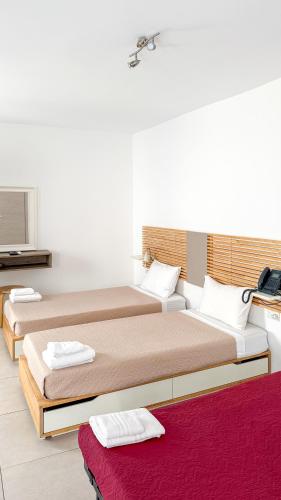 a room with two beds and a television at Island Guesthouse in Il-Gżira