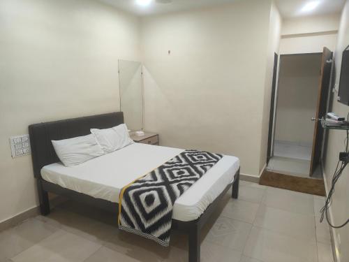 a small bedroom with a bed and a mirror at kathiyawadi Hotel somnath in Kevdi Road