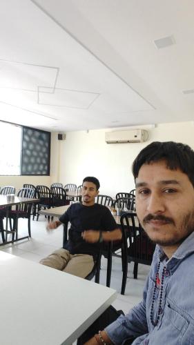 two men sitting at a table in a classroom at kathiyawadi Hotel somnath in Kevdi Road