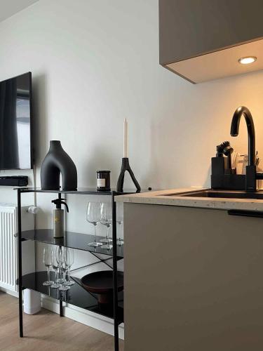 a kitchen with a counter with wine glasses on it at Central nyrenoveret lejlighed i Aalborg in Aalborg