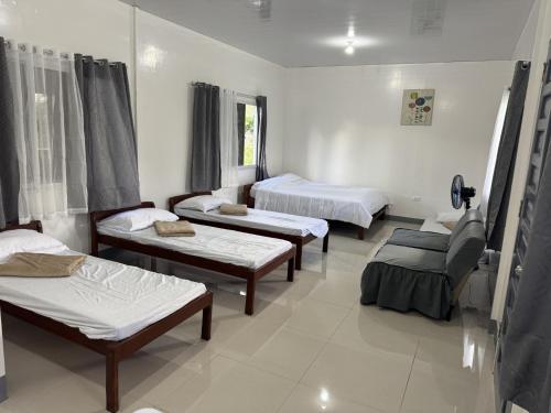 a hospital room with four beds and a couch at Helens Mountain Resort in Binungan