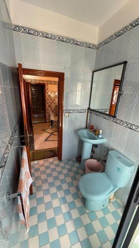 a bathroom with a blue toilet and a sink at Résidence chez Said in Sidi Ifni
