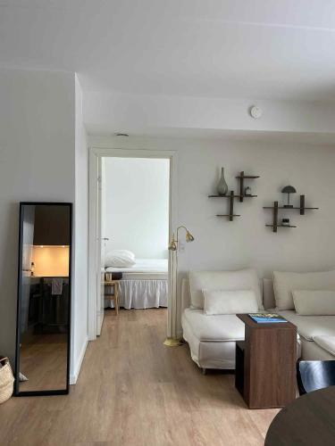a living room with a white couch and a table at Central nyrenoveret lejlighed i Aalborg in Aalborg