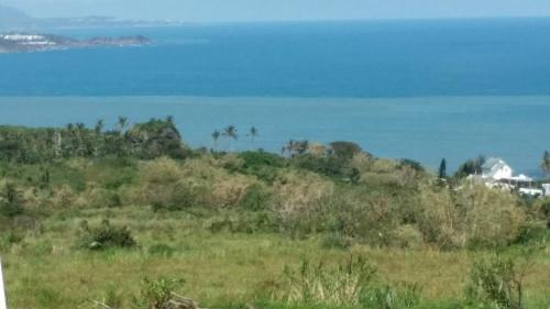 a grassy hill with the ocean in the background at Taitung Sansiantai B&B in Chenggong