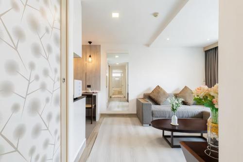 a living room with a couch and a table at Shine 43 Service Residence Bangkok in Bangkok