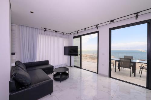 a living room with a couch and a view of the ocean at וילה לה מר - וילה עם בריכה ו-3 סוויטות מדהימות עם נוף לים המלח in Neve Zohar