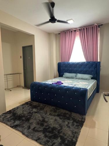 a blue bed in a room with a window at Teratak Amaris Homestay MELAYU ONLY in Sungai Petani