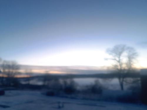 a view of a snowy field with the sun in the background at Gite du Châtelard in Thiébouhans
