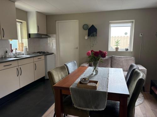 a kitchen with a dining room table with chairs and a table sidx sidx sidx at Knus huisje met palletkachel in Tiendeveen