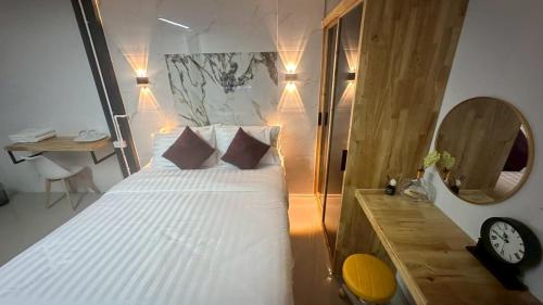 a bedroom with a bed with a clock and a desk at Villa Moon Terrace in Bang Khen