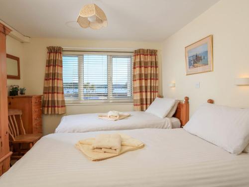 a bedroom with two beds and a window at 3 The Salcombe in Salcombe