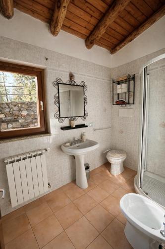 a bathroom with a sink and a toilet and a mirror at Altamarea Private Retreat in Corniglia