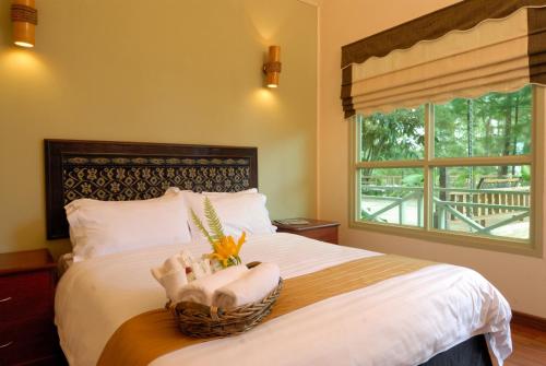 a bedroom with a bed with a basket of towels at Perkasa Mt Kinabalu , Sabah in Kampong Kundassan