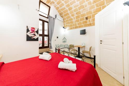 a bedroom with a red bed with towels on it at Casa di Ponente - Gallipoli in Gallipoli