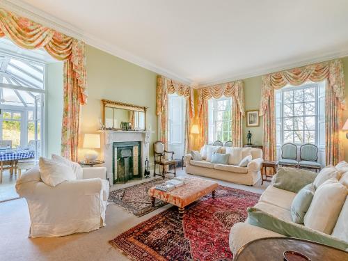 a living room with white furniture and a fireplace at Ladywell House in Falkland