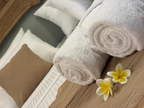 a hotel room with towels and flowers on a table at Villa Nature Glee in Dodanduwa