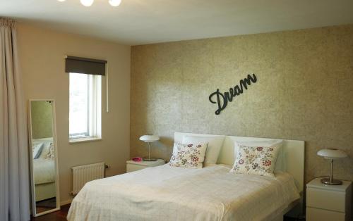 a bedroom with a bed with a sign on the wall at Casa Vista Duna - Kijkduin in The Hague