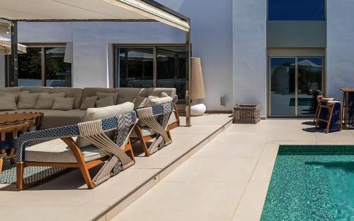 a living room with a couch and a swimming pool at Super views in Mykonos in Psarou