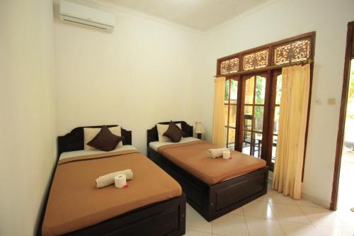 a room with two beds and a window at Jepun Bali Bungalow in Nusa Lembongan