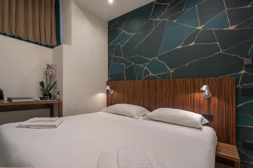 a bedroom with a large white bed with a wall at The Place in Milan