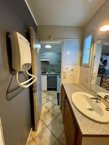a bathroom with a sink and a hair dryer on the wall at La Canotière in Saint-Georges-dʼOléron