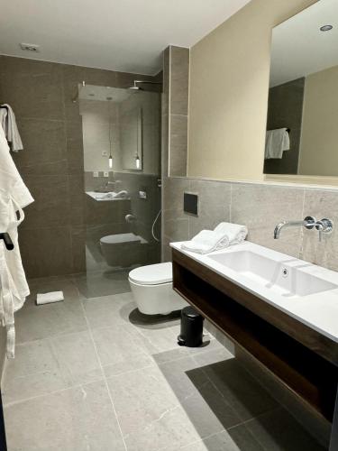 a bathroom with a sink and a toilet and a mirror at Hotel Coral Cotillo Reef in El Cotillo