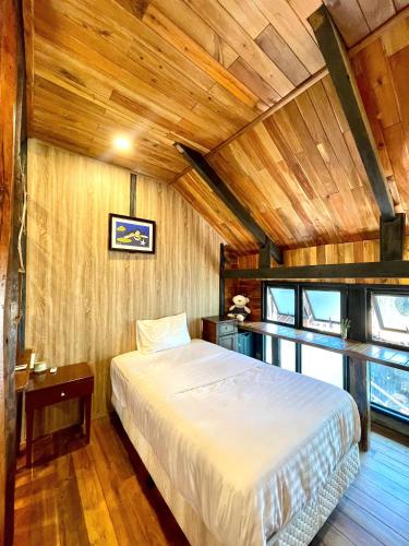 a bedroom with a bed and a wooden ceiling at Lam Mountain Retreat Ông Lang in Phú Quốc