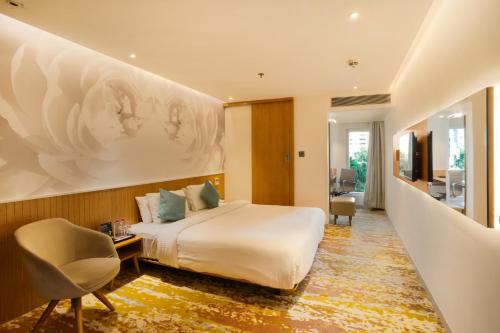 a hotel room with a bed and a large painting on the wall at Effotel by Sayaji Vadodara in Vadodara