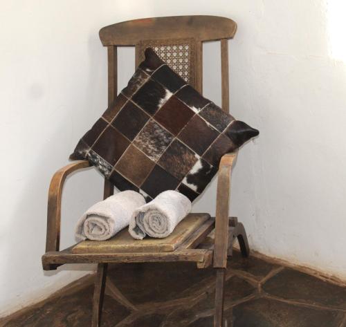 a wooden rocking chair with towels on it at Honey Farm Country Get Away in Skeerpoort