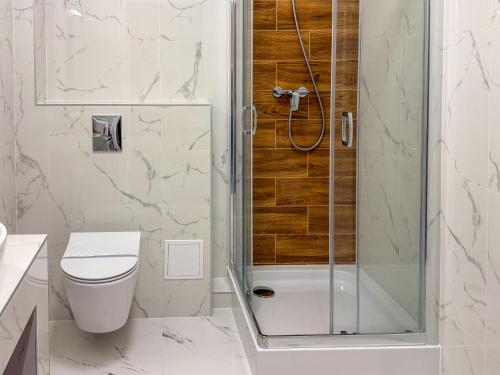 a bathroom with a toilet and a glass shower at Hotel Sjesta in Mikołów