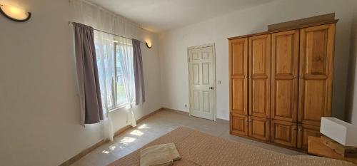 a room with a large window and a wooden cabinet at Beach front with Swimming pool, Illyria Resort Apt 101 in Milna