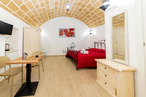 a bedroom with a red bed and a table at Casa di Levante - Gallipoli in Gallipoli