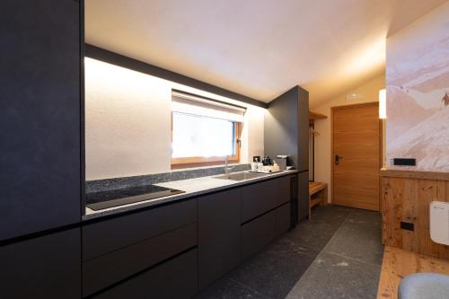 a large kitchen with a sink and a window at Breithorn Lodge in Champoluc