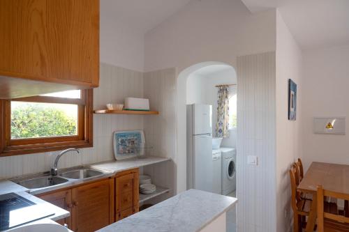 a kitchen with a sink and a white refrigerator at Villa Marta in Cala Blanca