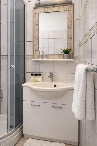 a white bathroom with a sink and a shower at Villa Una Maris - renovated 2026 in Pag