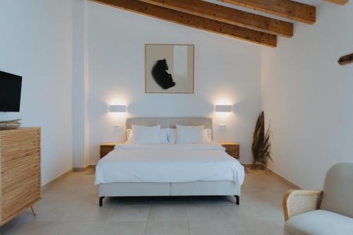 a white bedroom with a bed and a chair at Vino Resort Son Amaret in Son Macia