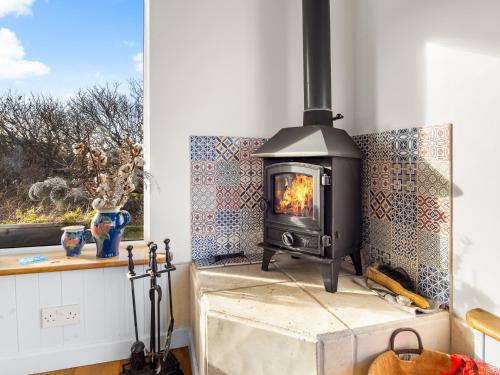 a wood stove in a room with a window at The Residence Renvyle in Renvyle